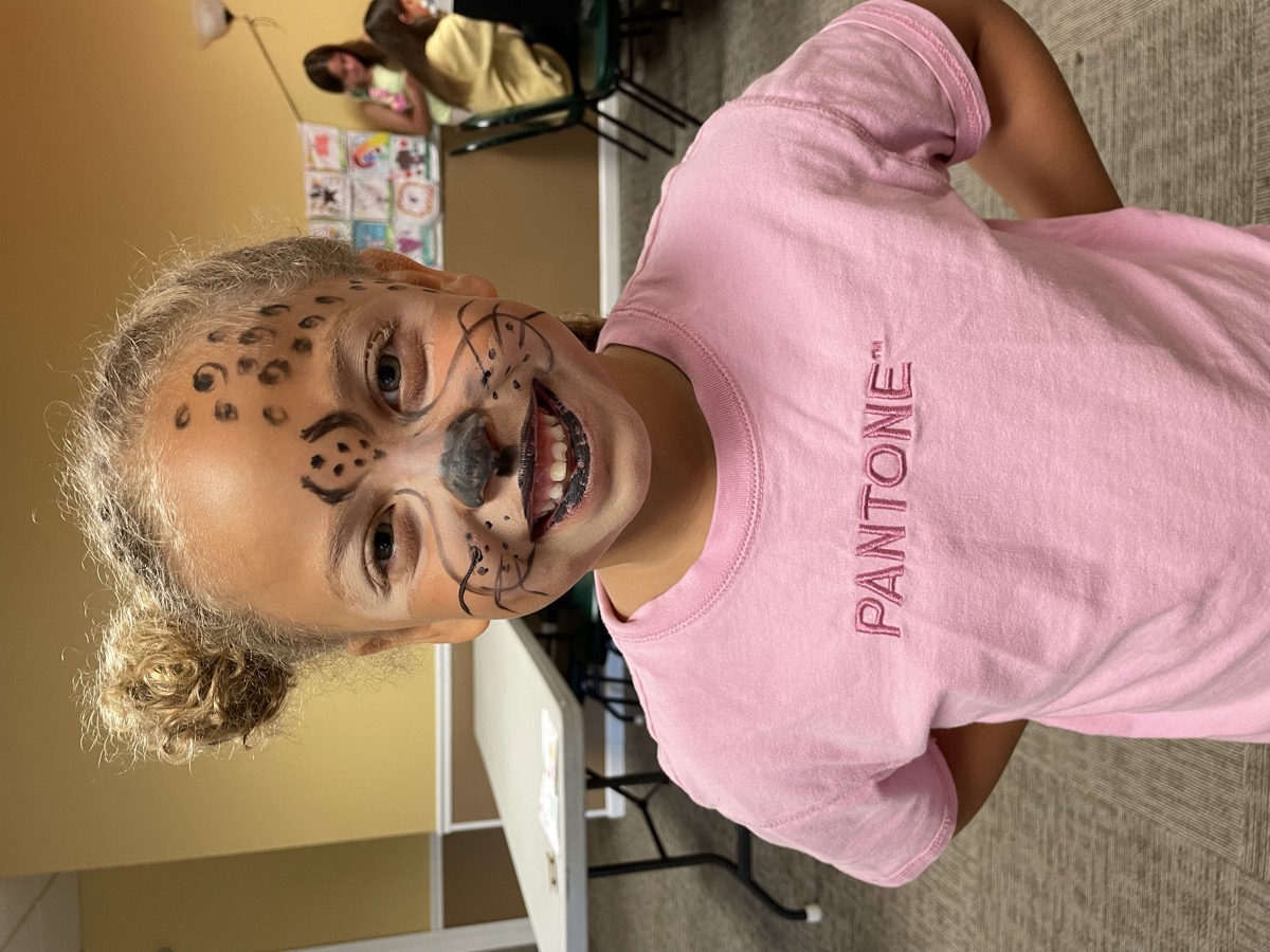 Girl with leopard face paint posing confidently